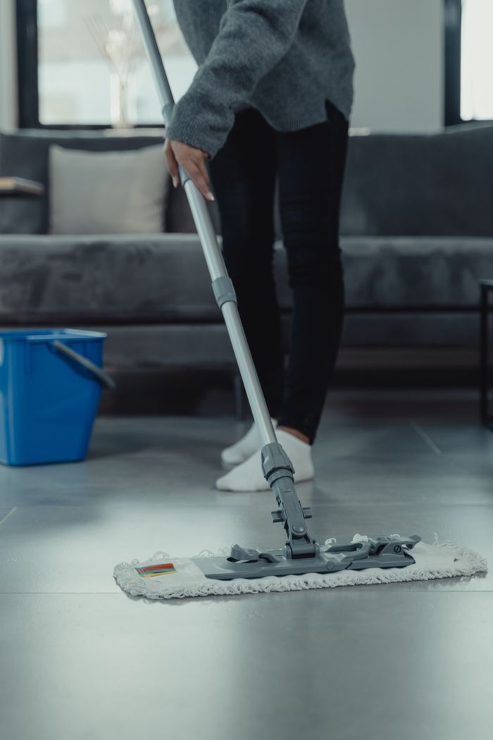 A mop and bucket on a freshly cleaned tiled floor