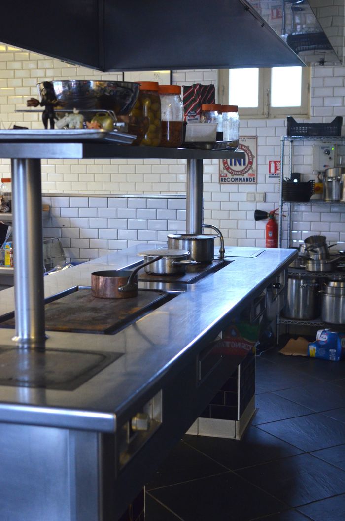 A commercial kitchen with stainless-steel surfaces being cleaned