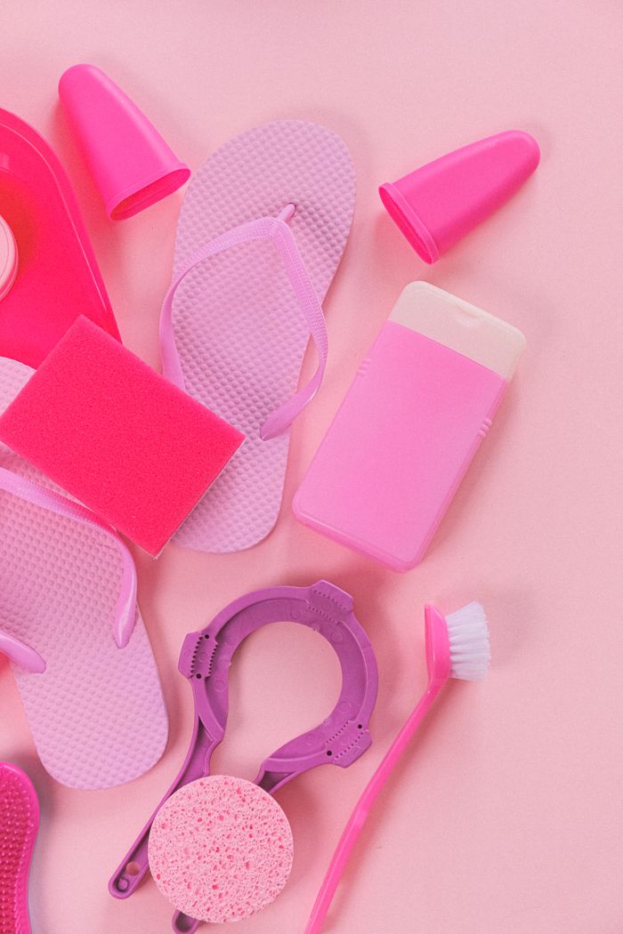 An overhead flat-lay of cleaning tools including detergent bottles, a brush, and a sponge